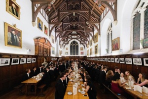 hall filled with people seated at long tables for formal dinner