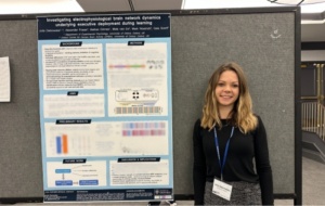 Julia Dabrowska - Cognitive Neuroscience Annual Meeting 2025 - woman standing in front of poster at a conference
